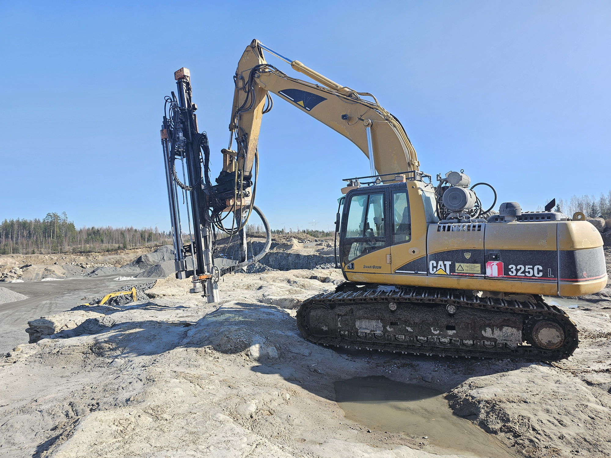 Doofor heavy-duty rock drill DFR8 mounted on an excavator is at work drilling bedrock.